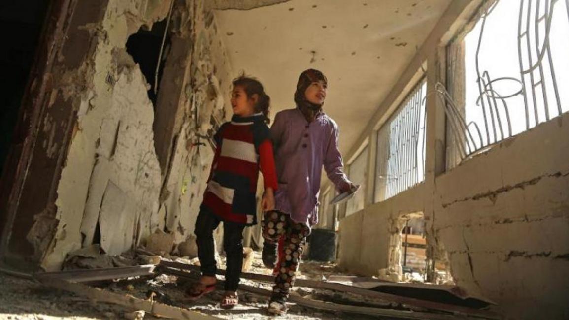 طفلتان وسط الدمار في الغوطة الشرقية(تويتر)