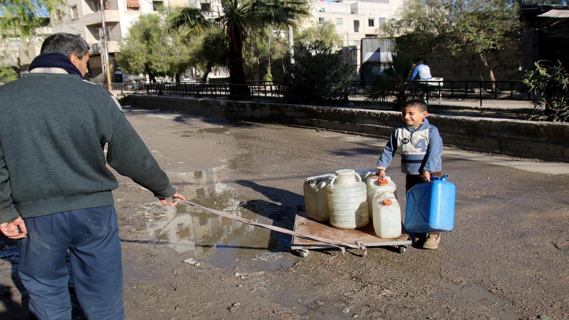 فرحة طفل سوري بالحصول على مياه شرب (بسام الشامي/الأناضول)