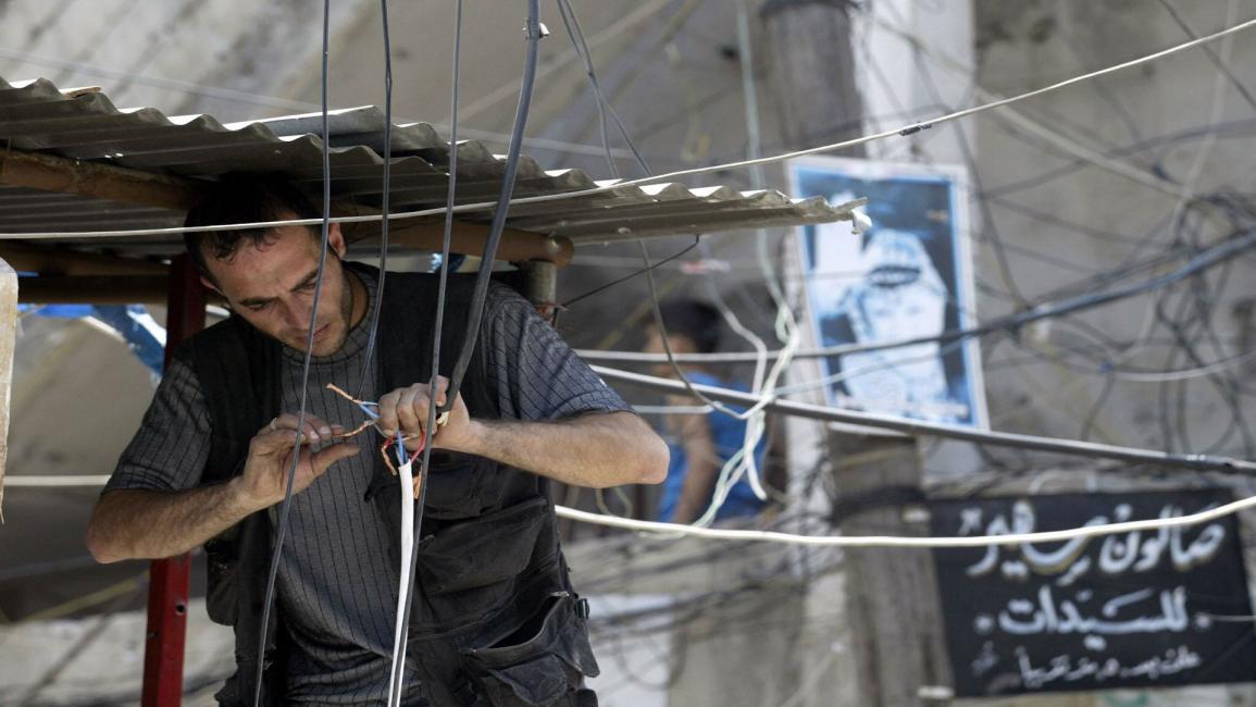 فلسطيني في عين الحلوة يمدد خطوط كهرباء (فرانس برس)