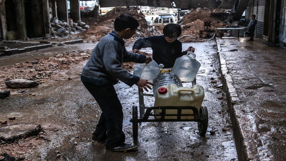 أطفال سوريون ينقلون المياه في حلب (فاليري شريفولين/Getty)