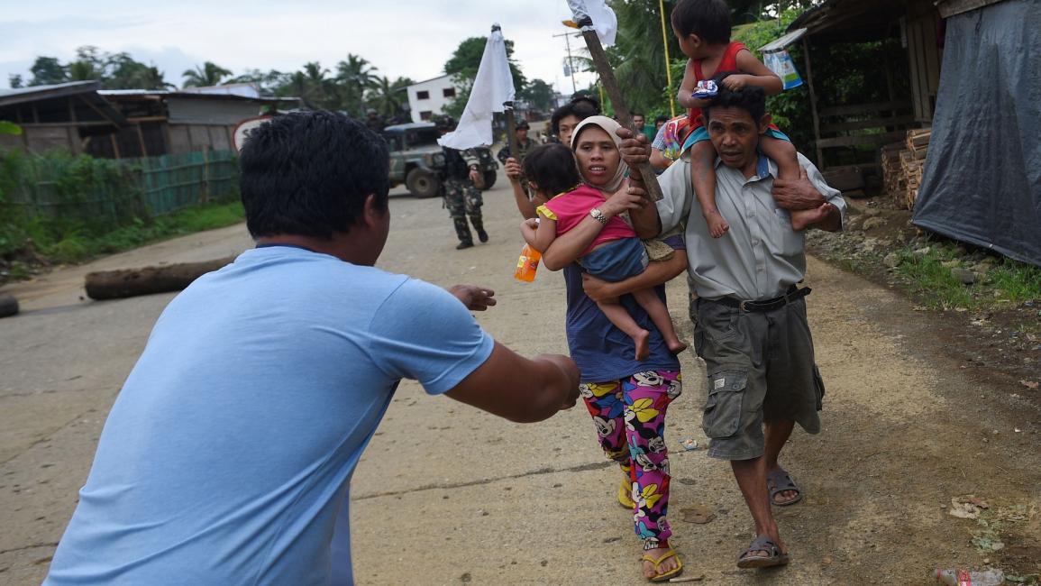 رجل وامرأة يحملان طفلان في الفيليبين - مجتمع