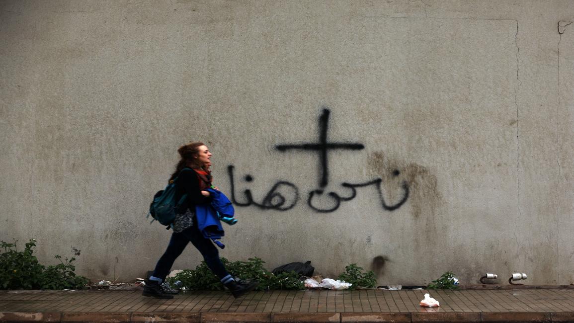 فتاة أمام شعار مسيحي في بيروت- فرانس برس