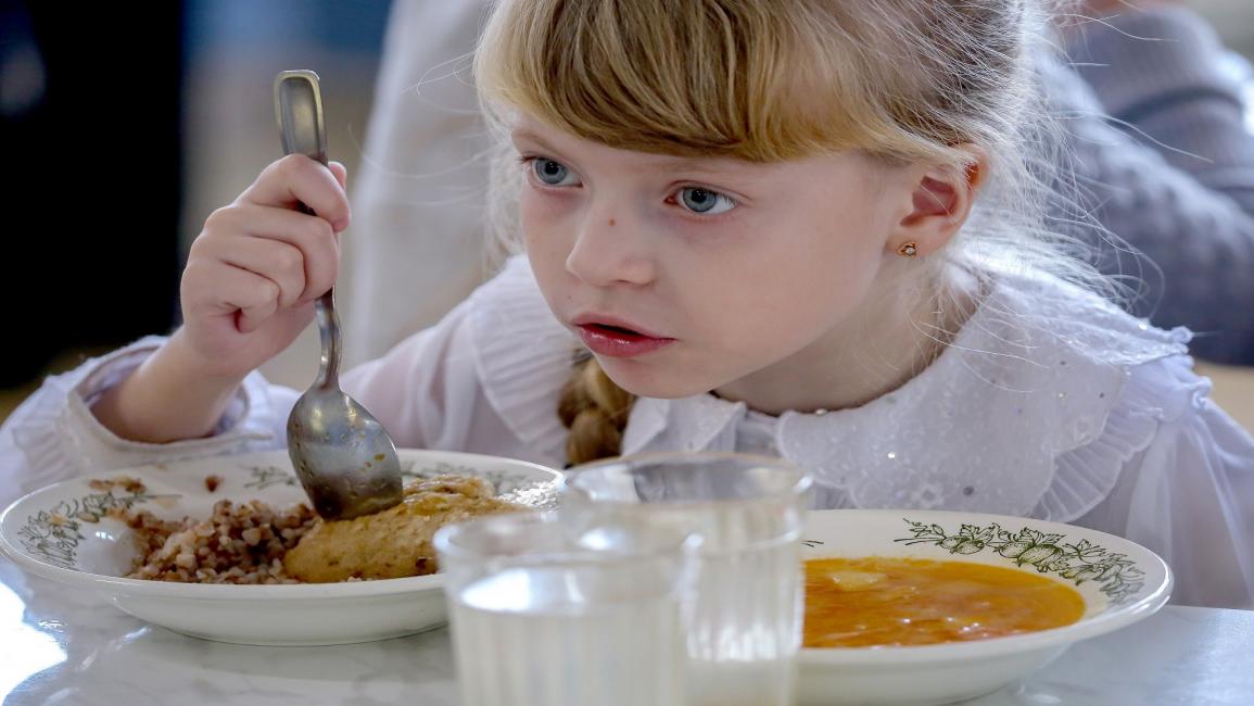 طفلة تتناول الطعام/مجتمع (ديمتري ريغولين/ Getty)