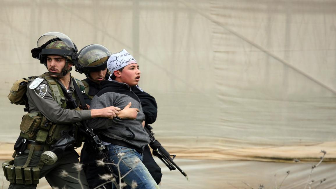 جنود إسرائيليون يعتقلون طفلا فلسطينيا في الضفة(سيف دحلة/فرانس برس)