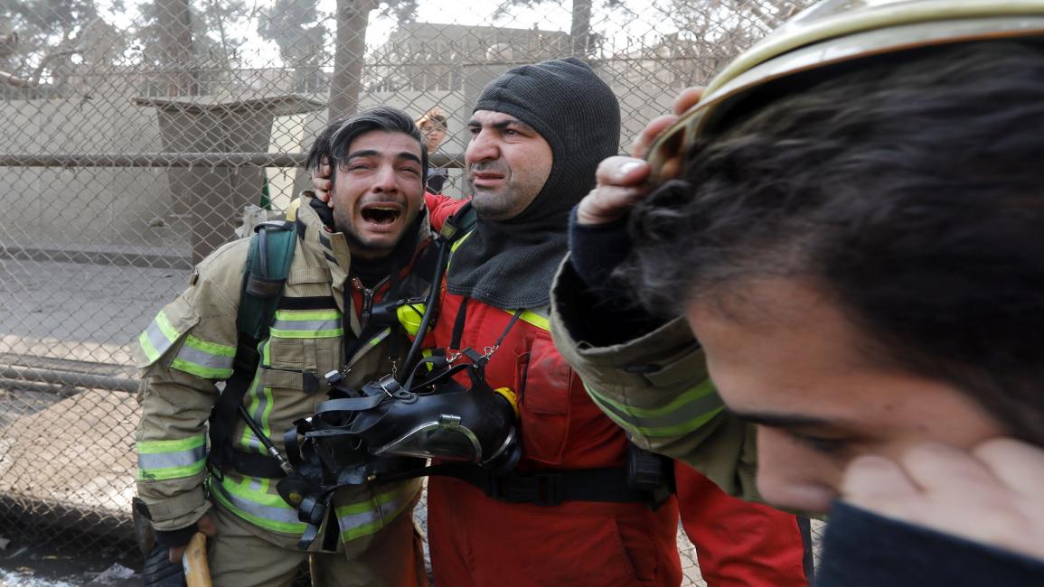 إيران-مجتمع-رجل إطفاء يبكي زملاء قضوا بانهيار برج بلاسكو(STR/فرانس برس)