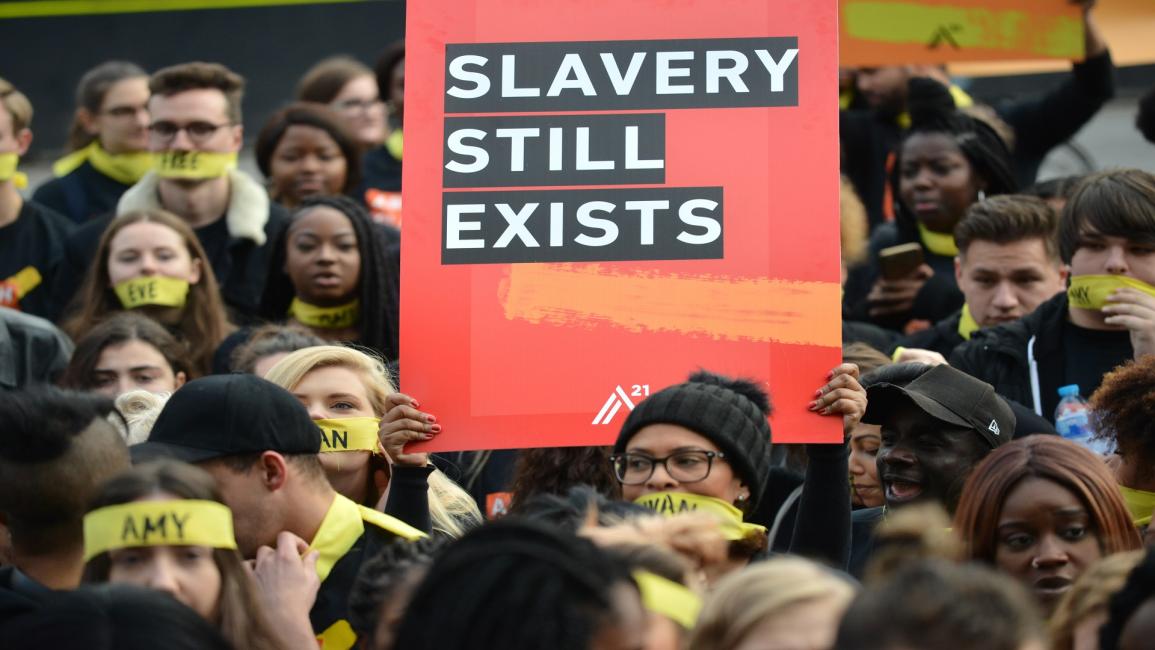 متظاهرون يرفعون شعار "العبودية لا تزال موجودة" (ماثيو شاتيل/Getty)