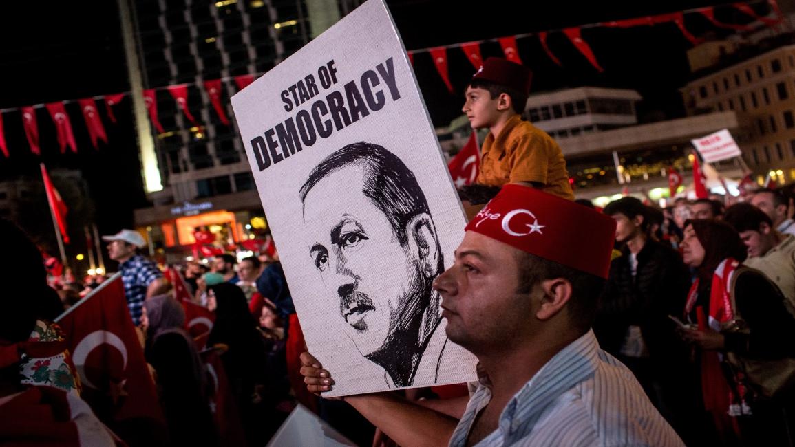 تركي يحمل صورة أردوغان في ساحة تقسيم