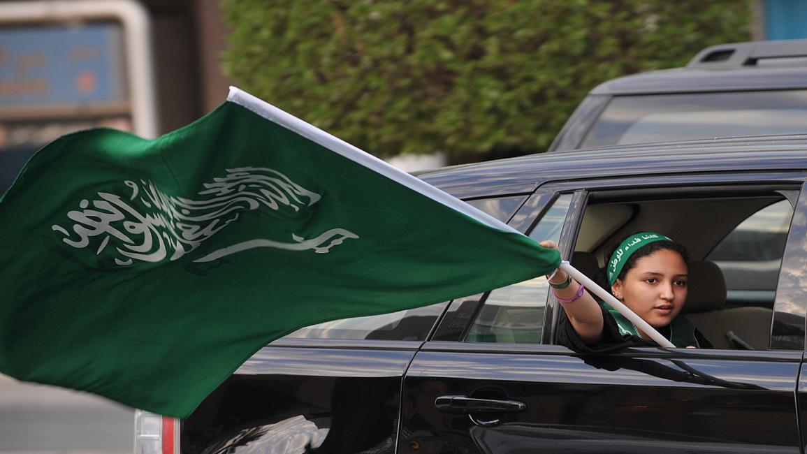 فتاة سعودية تحمل علم بلادها- فرانس برس