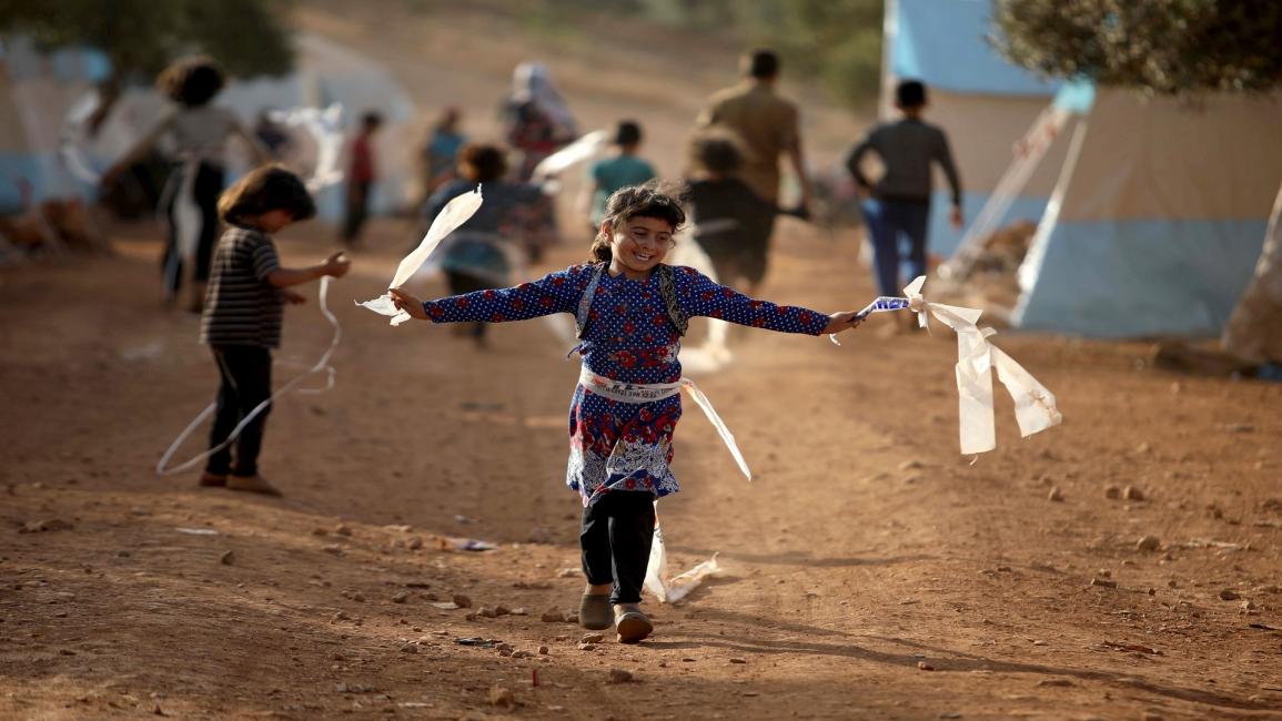 طفلة سورية نازحة تحتفل بالعيد في المخيم(عارف وتد/فرانس برس)