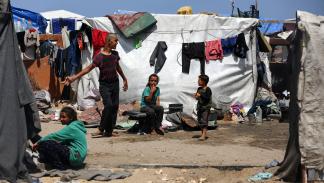 فلسطينيون في مخيم نزوح في دير البلح وسط قطاع غزة - 28 إبريل 2024 (مجدي فتحي/ Getty)