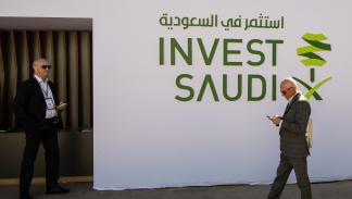 Getty-Businessmen stroll in front of the Saudi invest pavilion...