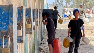 محاولة الحصول على مياه الشرب في محطة في دير البلح، 26 مايو 2024 (الأناضول)