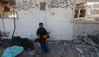 طفلان فلسطينيان يلعبان على أرجوحة وسط الدمار بخانيونس، في 16 يناير 2024 (فرانس برس)