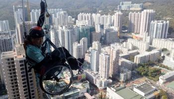 رجل بكرسي متحرك وشلل نصفي يتسلق ناطحة سحاب في هونغ كونغ- تويتر