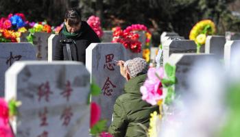 صينيون في مقبرة بمناسبة مهرجان تشينغ مينغ (فرانس برس)