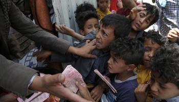 أطفال يتدافعون للحصول على وجبة غداء في اليمن (محمد حمود/ Getty)