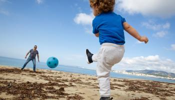 يلعب مع طفله على شاطئ مايوركا (خايمي رينا/ فرانس برس)