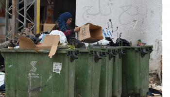 امرأة فقيرة تبحث في القمامة في تونس (فتحي بلعيد/ فرانس برس)