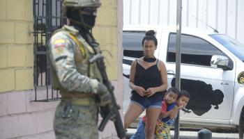 امرأة وولدان أمام مشهد الأمن الصارم (فرناندو منديز/ فرانس برس)