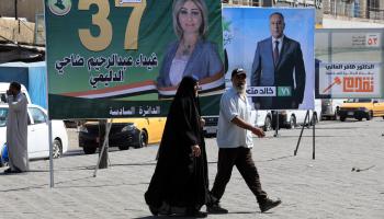 عراقيون ولافتات انتخابية في بغداد (مرتضى السوداني/ الأناضول)