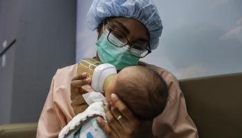 ممرضة تطعم طفلاً حديث الولادة (أنيس لين/ Getty)