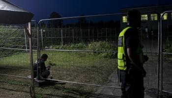 طالب لجوء وشرطي في مركز احتجاز في ليتوانيا (Getty)
