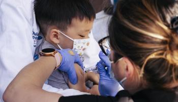 طفل صغير ولقاح فايزر-بيونتيك المضاد لكورونا (ليسلي لابوينت/ Getty)