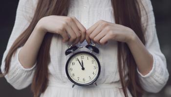 صورة تعبيرية - امرأة تحمل ساعة (Getty)