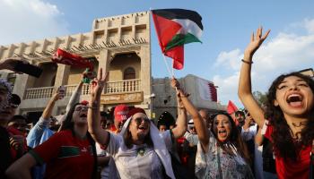 أنصار المنتخب المغربي يرفعون علم فلسطين في قطر (أشرف عمرة/ الأناضول)