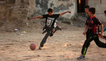 أطفال فلسطينيون يلعبون كرة القدم في غزّة، 2018 (Getty)