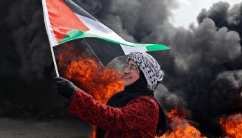 متظاهرة ترفع العلم الفلسطيني أثناء مظاهرة في الضفة الغربية (جعفر أشتيه/فرانس برس)