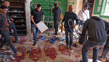 فلسطينيون يزيلون آثار اعتداء قوات الاحتلال على المسجد الأقصى (أحمد غرابلي/فرانس برس)