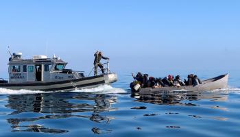 مهاجرون من أفريقيا جنوب الصحراء وحرس سواحل تونسي (جهاد عبد اللاوي/ رويترز)