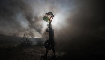 إشعال الإطارات ورفع العلم الفلسطيني في غزة احتجاجا على جرائم الاحتلال في جنين (على جاد الله/الأناضول)