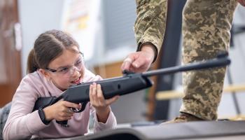تتعلم استخدام السلاح في أوكرانيا (ستانيسلاف إيفانوف/ Getty)