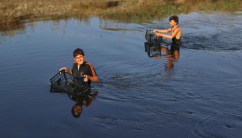أطفال يصطادون في نهر العاصي (عارف وتد/فرانس برس)