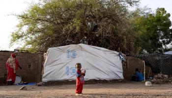 طفل نازح في السودان يعيش مع عائلته في خيمة في مدرسة (فرانس برس)