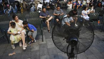صينيون ومراوح وسط موجة حر في الصين (غريغ بايكر/ فرانس برس)