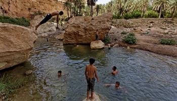 أطفال يسبحون في تجمع مائي في الجزائر (Getty)