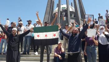 رفع علم الثورة السورية في احتجاجات السويداء (تويتر)