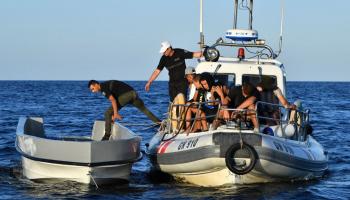 خفر السواحل التونسي ومهاجرون في البحر (فتحي بلعيد/ فرانس برس)