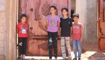 أطفال ليبيون أمام منزلهم المتضرر في مدينة سوسة (محمد شلش/Getty)