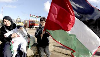 طفل جزائري بالكوفية الفلسطينية وآخر يحمل العلم الفلسطيني (العربي الجديد)