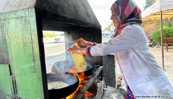تحضّر خبز التنور (الطاجين) على قارعة طريق (العربي الجديد)