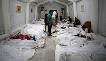 بحث بين جثث مجزرة مستشفى المعمداني في غزة (داوود نمر/ فرانس برس)