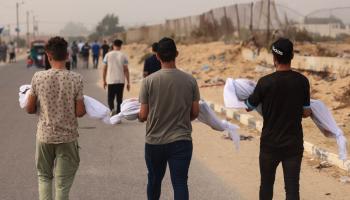 فلسطينيون يحملون جثامين شهداء في غزة (محمود الهمص/ فرانس برس)