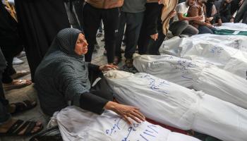 امرأة فلسطينية تبكي بجوار جثامين الشهداء الذين فقدوا أرواحهم في قصف إسرائيلي أمام مشفى في رفح جنوب قطاع غزة في 17/10/2023 (الأناضول)