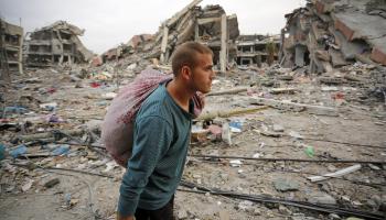 فلسطينيون وسط الدمار في قطاع غزة (أشرف أبو عمرة/ الأناضول)