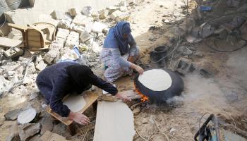 فلسطينيات وخبز على الموقدة وسط حرب غزة (أشرف أبو عمرة/ الأناضول)