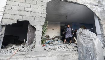 رجل فلسطيني يتفقد منزله الذي أصيب بقصف إسرائيلي في خانيونس جنوبيّ قطاع غزة في 4/12/2203 (Getty)